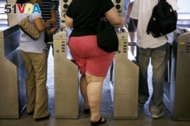 FILE: An overweight woman walks through a turnstyle. Half of Americans will be obese by 2030, says a new study.