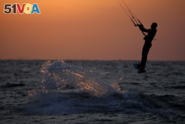 A man surfs with his kitesurfing board in the Mediterranean sea in Ashkelon as restrictions following the coronavirus disease (COVID-19) ease around Israel May 11, 2020.