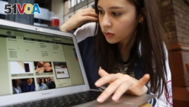 FILE - Nathaly Ordonez studies the home page for the tuition-free, online University of the People, Thursday, Nov. 5, 2015, in New York. (AP Photo/Kathy Willens)