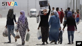 Syrian refugees walk at a refugee camp in Suruc, on the Turkey-Syria border, Friday, June 19, 2015. (AP Photo/Emrah Gurel)