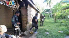 Police and soldiers take position as they engage with the Abu Sayyaf group in the village of Napo, Inabanga town, Bohol province, in the central Philippines on April 11, 2017.