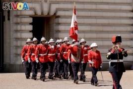 Canadian Captain Megan Couto, second right, makes history by becoming the first female Captain of the Queen's Guard as she takes part in the Changing the Guard ceremony at Buckingham Palace in London, Monday, June 26, 2017.