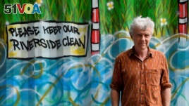 Activist, environmentalist and community leader Peter Macfadyen stands next to a painted storage unit on the banks of the River Frome, in Frome, Britain, June 25, 2019. Picture taken June 25, 2019. REUTERS/Toby Melvill