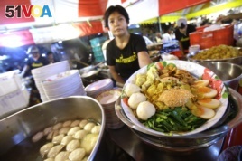 A street food vendor displays a bowl of Bamee Jom Palang, or 