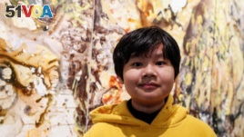 Xeo Chu, a young Vietnamese artist, stands in front of one of his pieces before his first solo show at the Georges Berges Gallery in New York City, New York, U.S., December 18, 2019. REUTERS/Shannon Stapleton