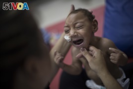 One-year-old Jose Wesley Campos, who was born with microcephaly, cries during a physical treatment at the AACD rehabilitation center in Recife, Brazil, Sept. 28, 2016.