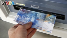 FILE - A 100 franc bank note is pulled from an ATM in Kreuzlingen, Switzerland.