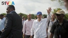 FILE - U.N. Secretary-General Ban Ki-moon, center wearing blue cap, greets residents during the launching of sanitation campaign in Hinche, Haiti, July 14, 2014.