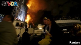 People run away as a fire engulfs The Address Hotel in downtown Dubai in the United Arab Emirates December 31, 2015. (REUTERS/Ahmed Jadallah)