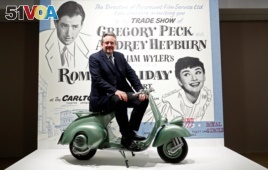 Audrey Hepburn's son, Sean Hepburn Ferrer, poses on the Vespa scooter his mother rode on in the 1953 movie 