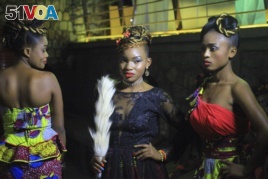 In this photo taken Saturday Dec. 23, 2017, Models pose for a photograph back stage before a fashion show in Beni Eastern Congo .