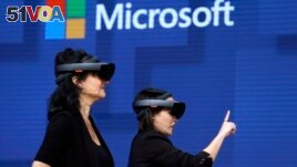FILE- In this May 11, 2017, file photo, members of a design team at Cirque du Soleil demonstrate use of Microsoft's HoloLens device in helping to virtually design a set at the Microsoft Build 2017 developers conference in Seattle. Federal contract records