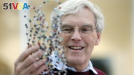 Richard Henderson, one of the 2017 Nobel Prize winners in Chemistry, holds a bacterio rhodopsin model prior to a press conference at the Laboratory of Molecular Biology in Cambridge, England, Wednesday, Oct. 4, 2017. 