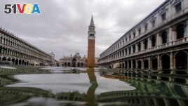 In this Friday, Nov. 15, 2019 file photo, a view of flooded St. Mark's Square in Venice, Italy. The square floods during an 80-centimeter rise. Water gets into the building itself at 88 centimeters. (AP Photo/Luca Bruno, File)
