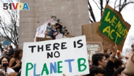 Students hold placards during a demonstration against climate change at Columbus Circle in New York, March 15, 2019. 