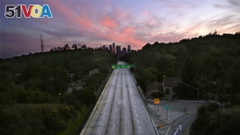 FILE - In this April 26, 2020, file photo, empty lanes of the 110 Arroyo Seco Parkway that leads to downtown Los Angeles is seen during the coronavirus outbreak in Los Angeles, Calif. (AP Photo/Mark J. Terrill, File)