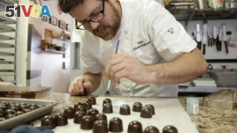 A chef in Miami, Florida puts some color onto freshly made bonbons, with chocolate made from cacao beans from Venezuela.