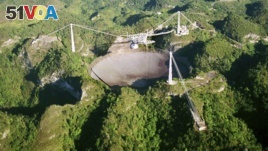 FILE- In this March 26, 2003, file photo, the world's largest radio telescope is seen from the air, at the Arecibo Observatory, in Puerto Rico. (AP Photo/ Tomas van Houtryve, File)