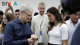 Apple CEO Tim Cook, left and soccer player Alex Morgan discuss the new Apple Watch 4 at the Steve Jobs Theater during an event to announce new products Wednesday, Sept. 12, 2018, in Cupertino, Calif. (AP Photo/Marcio Jose Sanchez)