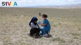 A health worker traveled hundreds of kilometers on July 8, 2021 to get things done. She gave COVID-19 shots to farmworkers in the village of Oguzlar in Turkey. (Photo by Adem ALTAN / AFP)