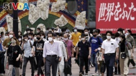 People wearing masks against the spread of the new coronavirus walk at Shibuya pedestrian crossing in Tokyo Friday, July 31, 2020. The Japanese capital confirmed Friday more than 400 new coronavirus cases. (AP Photo/Eugene Hoshiko)