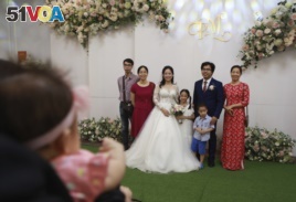Bride Thanh Mai and groom Duc Trung pose for a photo with their relatives during their wedding in Hanoi, Vietnam on Sunday, Jun. 28, 2020. The couple held their wedding, which was postponed in March due to social lockdown, as Vietnam eases back to normal.
