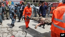 An Afghan municipality worker carries the body of a Taliban after clashes in front of the Parliament, in Kabul, Afghanistan,  June 22, 2015. 