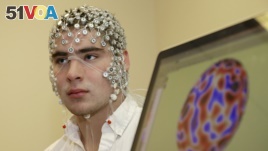In this May 31, 2013, photo, research assistant Kevin Real wears an EEG net for detecting brain activity which is hooked up to a monitor, at the University of Nebraska's Center for Brain, Biology and Behavior in Lincoln, Nebraska. (AP Photo/Nati Harnik)