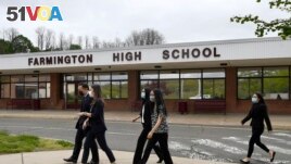 Connecticut Attorney General William Tong left, walks with teacher Clarissa Tan, second from left, and students from the Asian American Student Union after speaking at a program for Asian Pacific American Heritage Month at Farmington High School in Farmington, Conn on May 10, 2020. (AP Photos/Jessica Hill)