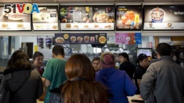 FILE - In this June 22, 2016 photo, customers stand in line at a fast food restaurant in Santiago, Chile. A new food labeling law went into effect on Monday in Chile, a country with the world's highest rates of childhood obesity. (AP Photo/Esteban Felix)