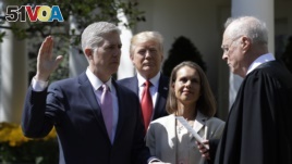 President Donald Trump watches as Supreme Court Justice Anthony Kennedy administers the judicial oath to Judge Neil Gorsuch during a re-enactment in the Rose Garden of the White House White House in Washington, April 10, 2017.