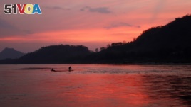 In this March 4, 2011, file photo, men ride in a boat across the Mekong River in Luang Prabang, Laos. It is officially described as the best-preserved city in Southeast Asia, a bygone seat of kings tucked into a remote river valley of Laos. Luang Prabang 