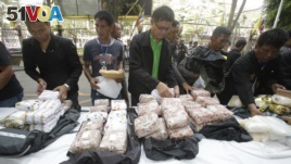 Thai policemen display drugs during a press conference in Bangkok, Thailand on March 24, 2016. They had seized 226 kilograms of crystalline methamphetamine and 8 kilograms of heroin. Thai police have arrested 15 Malaysians.