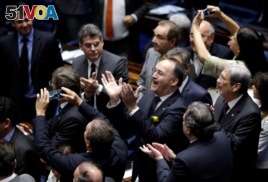 Members of Brazil's Senate react after a vote to impeach President Dilma Rousseff for breaking budget laws in Brasilia, Brazil, May 12, 2016.