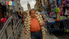 A man carries a strip of garlic during the garlic fair in Vitoria, northern Spain, July 2016. (AP Photo/Alvaro Barrientos)