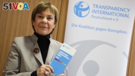 Edda Mueller, chairwoman of Transparency International Germany, stands for the media with the Corruption Perceptions Index 2018, before the presentation of the yearly report at a news conference in Berlin, Germany, Jan. 29, 2019.