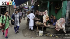 People walk past a shop selling cow meat in Kolkata, capital of the eastern Indian state of West Bengal.