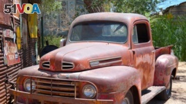 A very old red Ford pick-up truck. Some might call it 