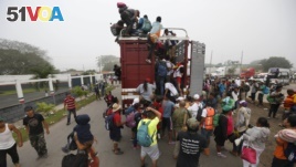 Central American migrants pack into the back of a trailer truck as they begin their morning trek as part of a thousands-strong caravan hoping to reach the U.S. border, in Isla, Veracruz state, Mexico, Nov. 4, 2018.