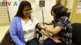 In this photo taken April 11, 2013, Liz DeRouen gets her blood pressure checked by medical assistant Jacklyn Stra at the Sonoma County Indian Health Project in Santa Rosa, California.