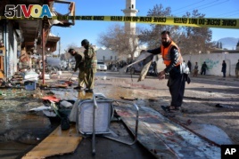Pakistani security officials examine at the site of suicide bombing in Quetta, Pakistan, Wednesday, Jan. 13, 2016. The suicide attack on a polio vaccination center in southwestern Pakistan killed more than a dozen people and wounded many.