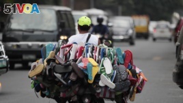 A man sells rubber flip-flops on his motorcycle in Manila, Philippines, 2013. (AP Photo/Aaron Favila)