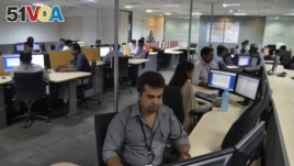 In this file photo, employees of ISGN work at their stations inside the company headquarters in the southern Indian city of Bangalore, India.