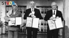 PLO leader Yasser Arafat, left, Israeli Prime Minister Yitzhak Rabin, center, and Israeli Foreign Minister Shimon Peres pose with their medals and diplomas, after receiving the 1994 Nobel Peace Prize in Oslo's City Hall, Dec. 10, 1994.