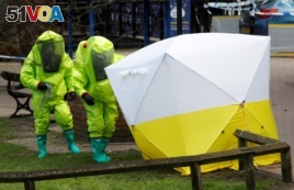 The forensic tent, covering the bench where Sergei Skripal and his daughter Yulia were found, is repositioned by officials in protective suits in the center of Salisbury, Britain, March 8, 2018.