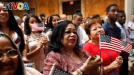 New citizens stand during a U.S. Citizenship and Immigration Services (USCIS) naturalization ceremony at the New York Public Library in Manhattan, New York, July 3, 2018. 