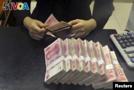 Zimbabwe announced that it is adopting the Chinese yuan as its reserve currency. In this photo, a clerk counts 100 Chinese yuan banknotes at the China Merchants Bank in Hefei, China. (Reuters) 