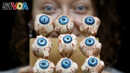 Cake Artist Sarah King displays her eyeball cakes at the 'Feed the Beast extreme cake shop' in London, Oct. 24, 2013. 