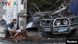 A boy sits next to a car destroyed by a Saudi-led air strike in Yemen's northwestern province of Amran, Aug. 29, 2015. (REUTERS/Khaled Abdullah)