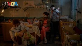 Hospital workers take care of orphaned children at the children's regional hospital maternity ward in Kherson, southern Ukraine on November 22, 2022. (AP Photo/Bernat Armangue)